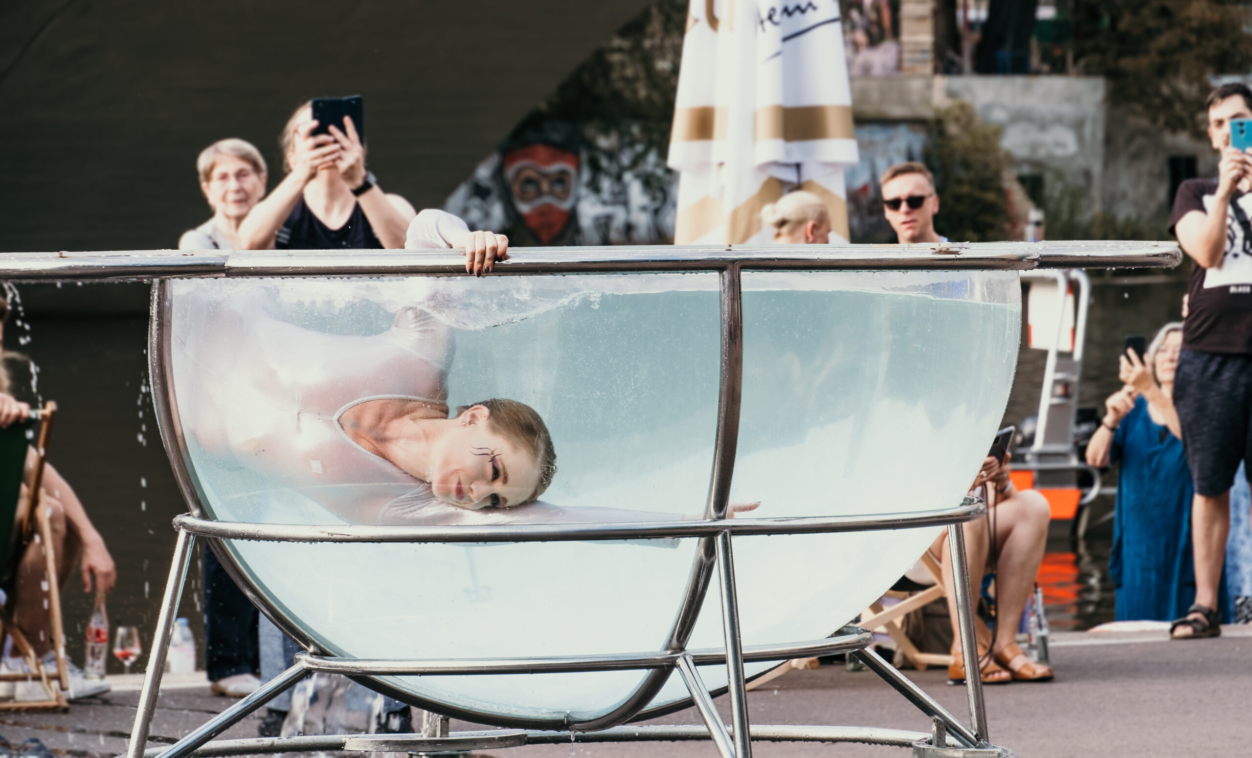 Waterbowl-Performance in einer gläsernen Wasserschale vor dem Publikum